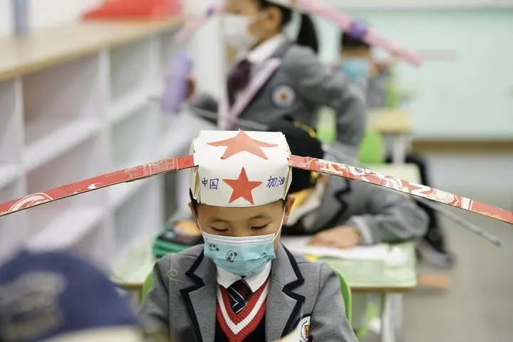 smart solution! chinese kids wear hats to keep social distance